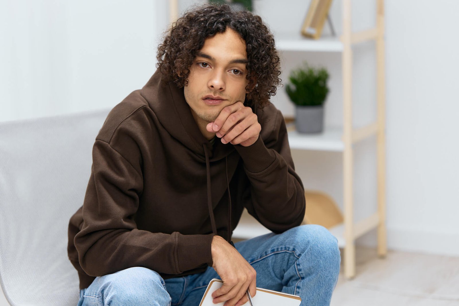 guy with curly hair sit on a chair with a notepad 2023 11 27 05 12 23 utc.jpg